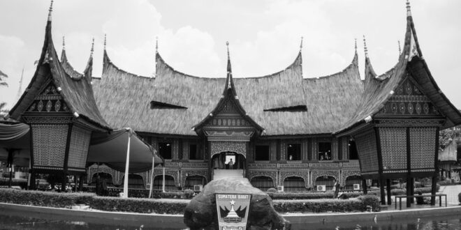 Eksterior modern rumah Graha Raya dengan desain minimalis, taman hijau, dan pencahayaan alami