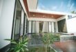 Rumah satu lantai mewah dengan desain modern, kolam renang, taman tropis, dan pencahayaan alami yang elegan.