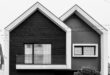 Rumah tingkat minimalis sederhana dengan desain modern, warna netral, dan taman kecil di depan.