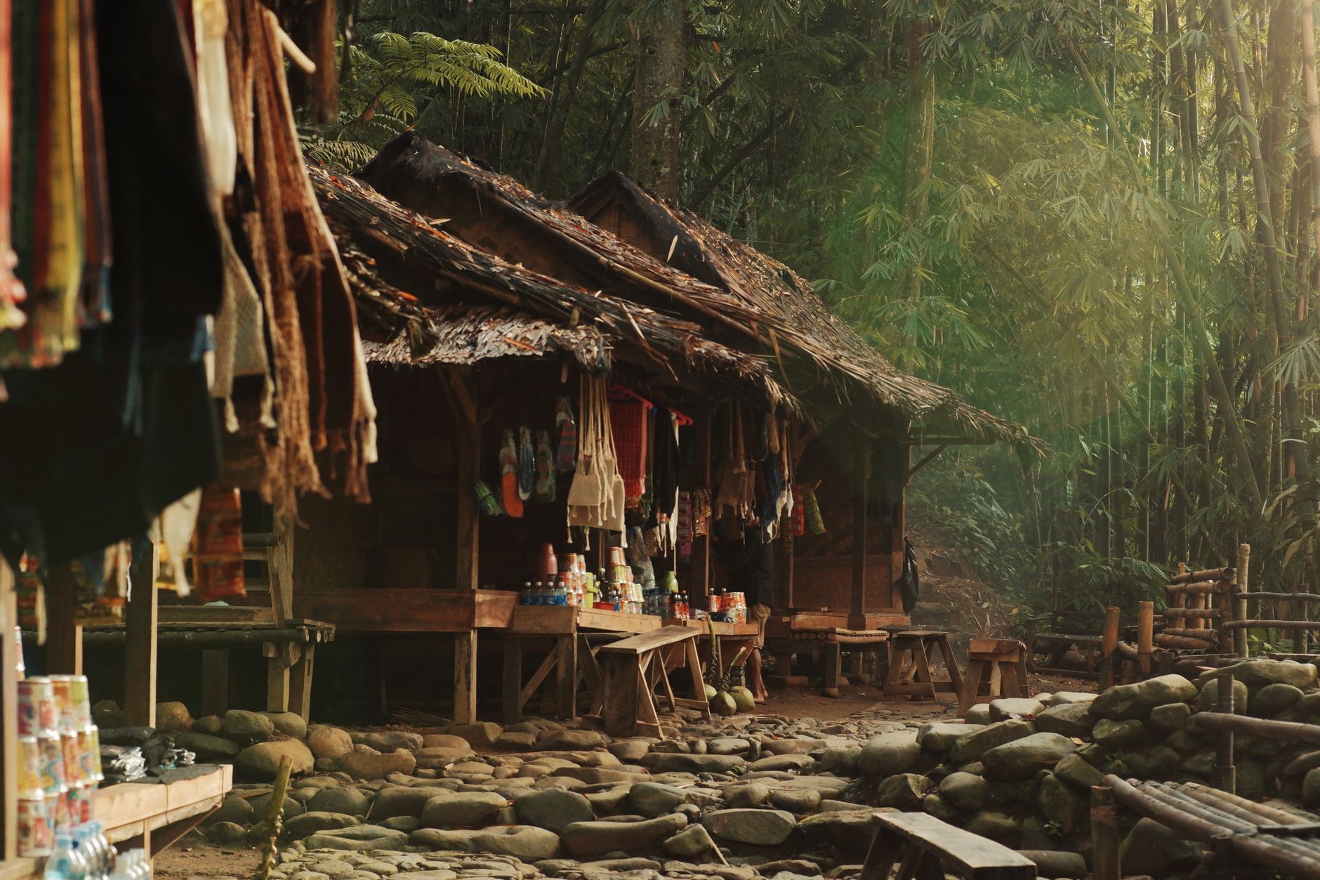 Desain warung sembako sederhana dengan rak kayu, lampu gantung, dan nuansa pedesaan di sebuah kampung.