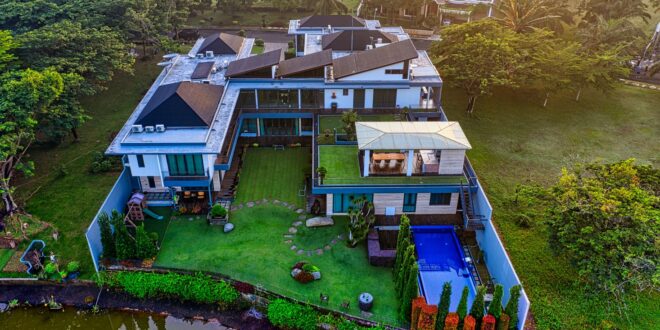 Rumah mewah dengan interior elegan, kolam renang, dan taman luas mencerminkan gaya hidup orang kaya.