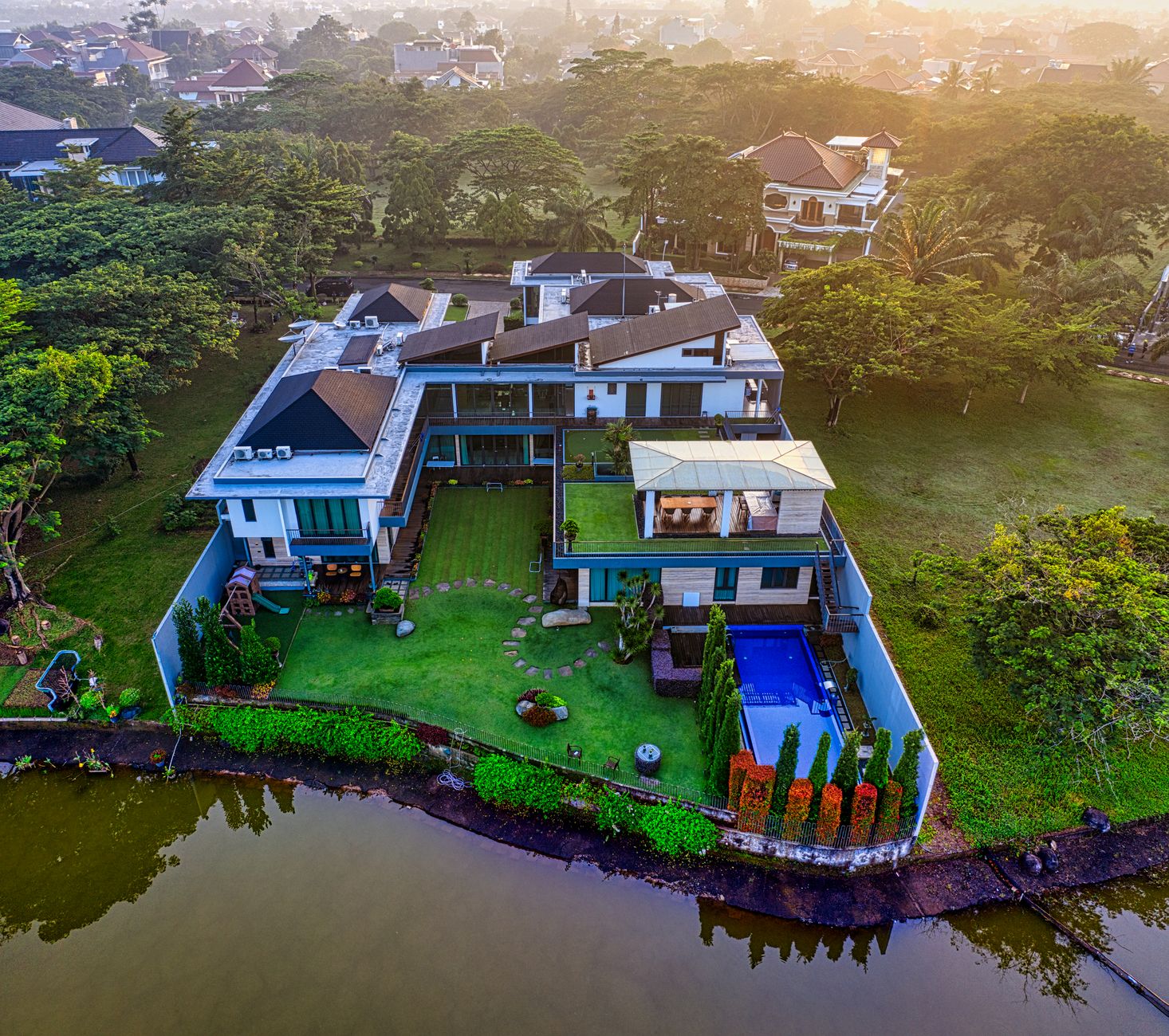 Rumah mewah dengan interior elegan, kolam renang, dan taman luas mencerminkan gaya hidup orang kaya.