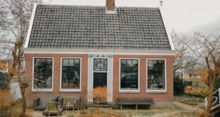 Foto rumah sederhana berukuran 5x7 meter dengan desain minimalis dan taman kecil di depan.