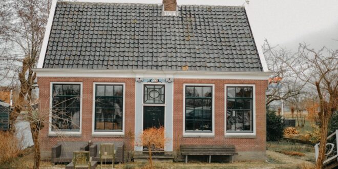 Foto rumah sederhana berukuran 5x7 meter dengan desain minimalis dan taman kecil di depan.