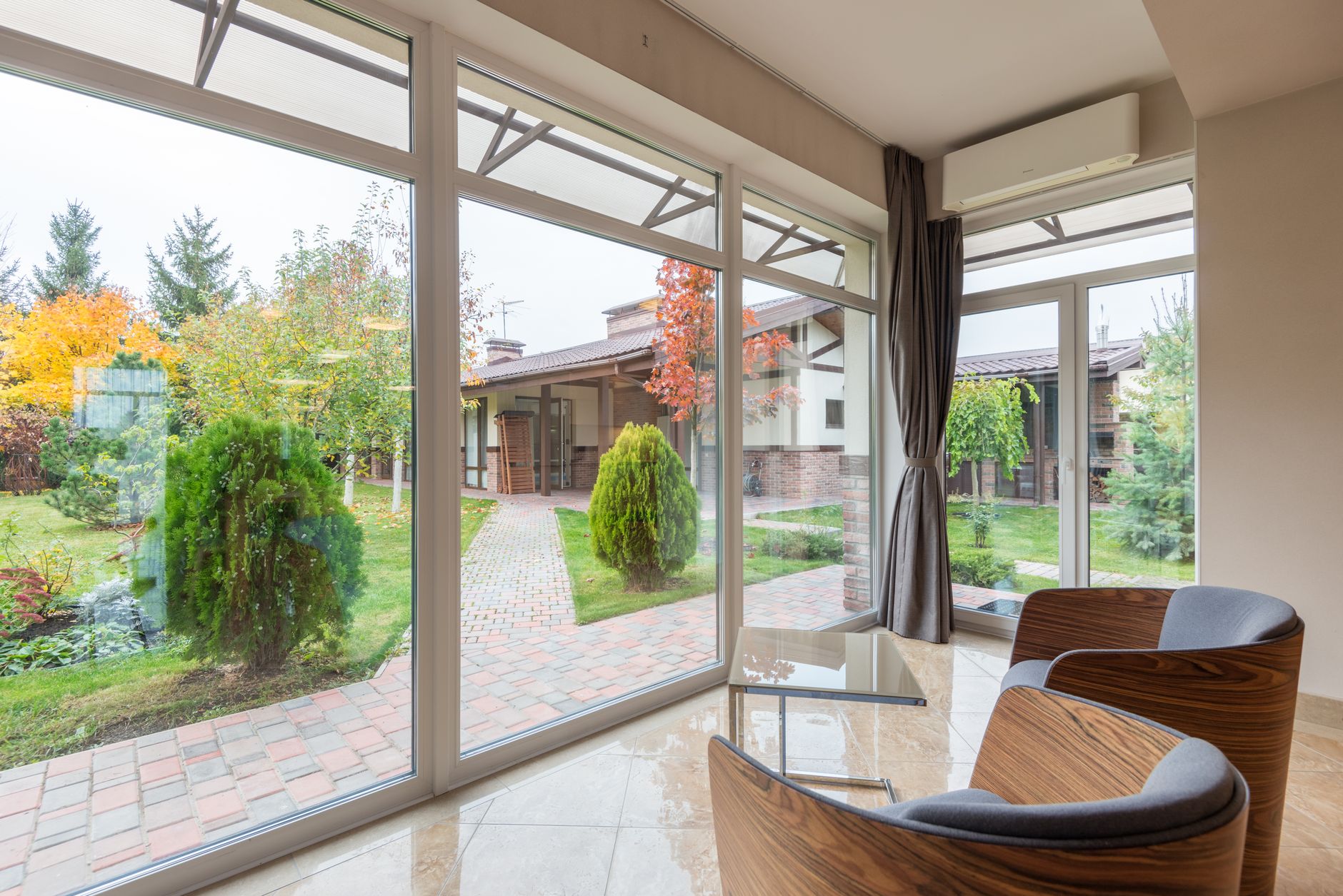 Desain rumah kaca minimalis sederhana dengan struktur transparan dan taman hijau modern.